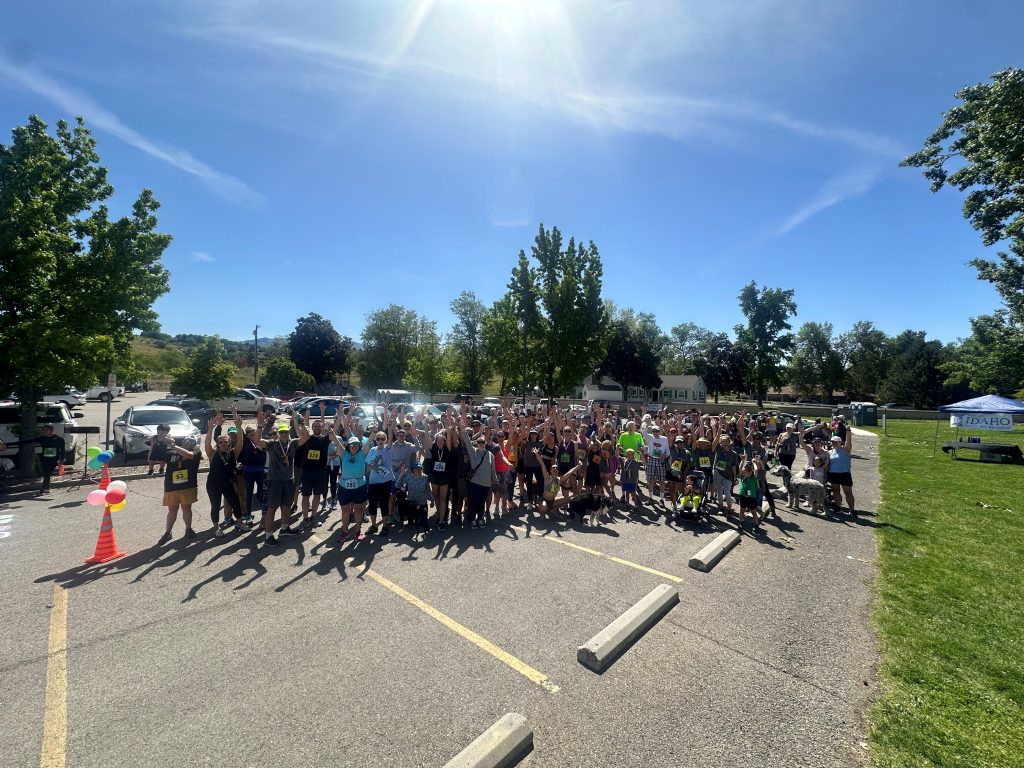 group of people smiling outside in running gear
