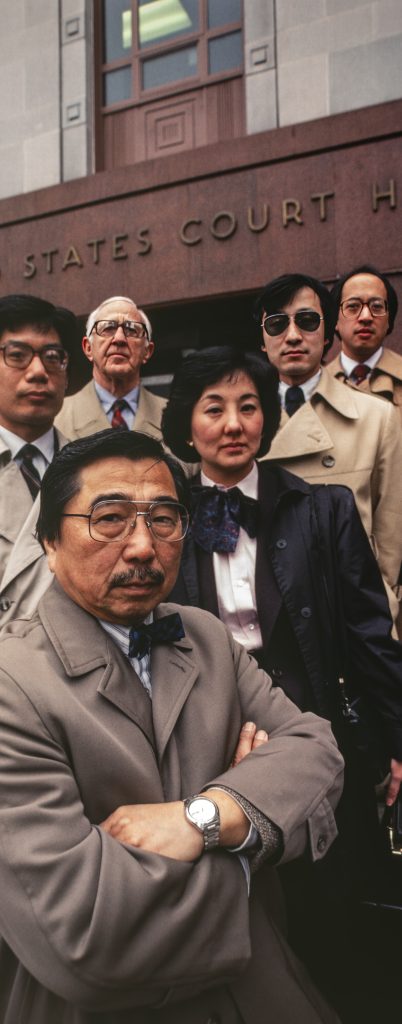 men and one woman standing on steps of a courthouse