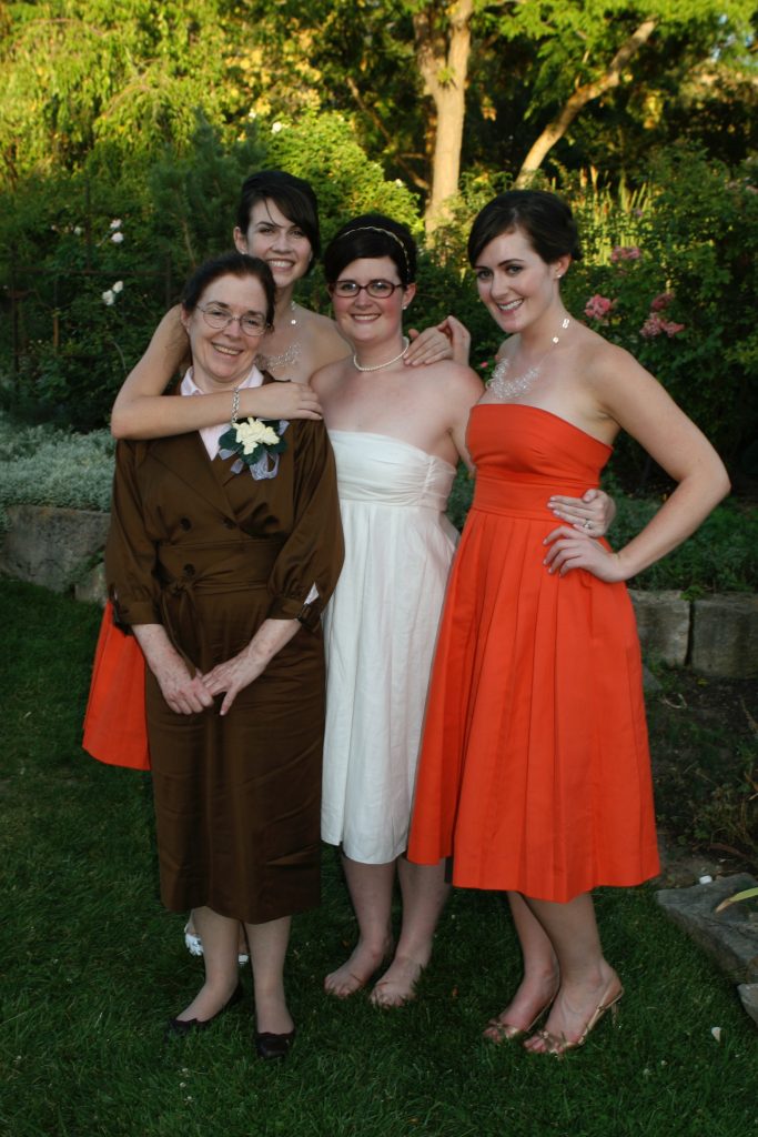 Woman and daughters smiling outside