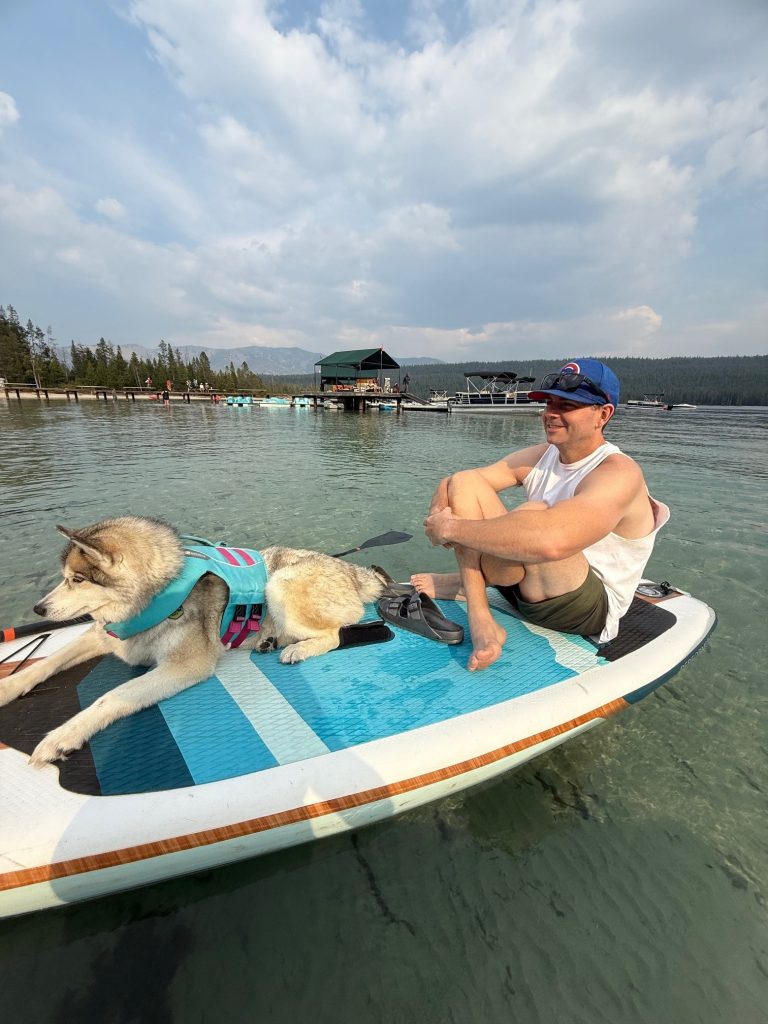 man on watercraft with dog