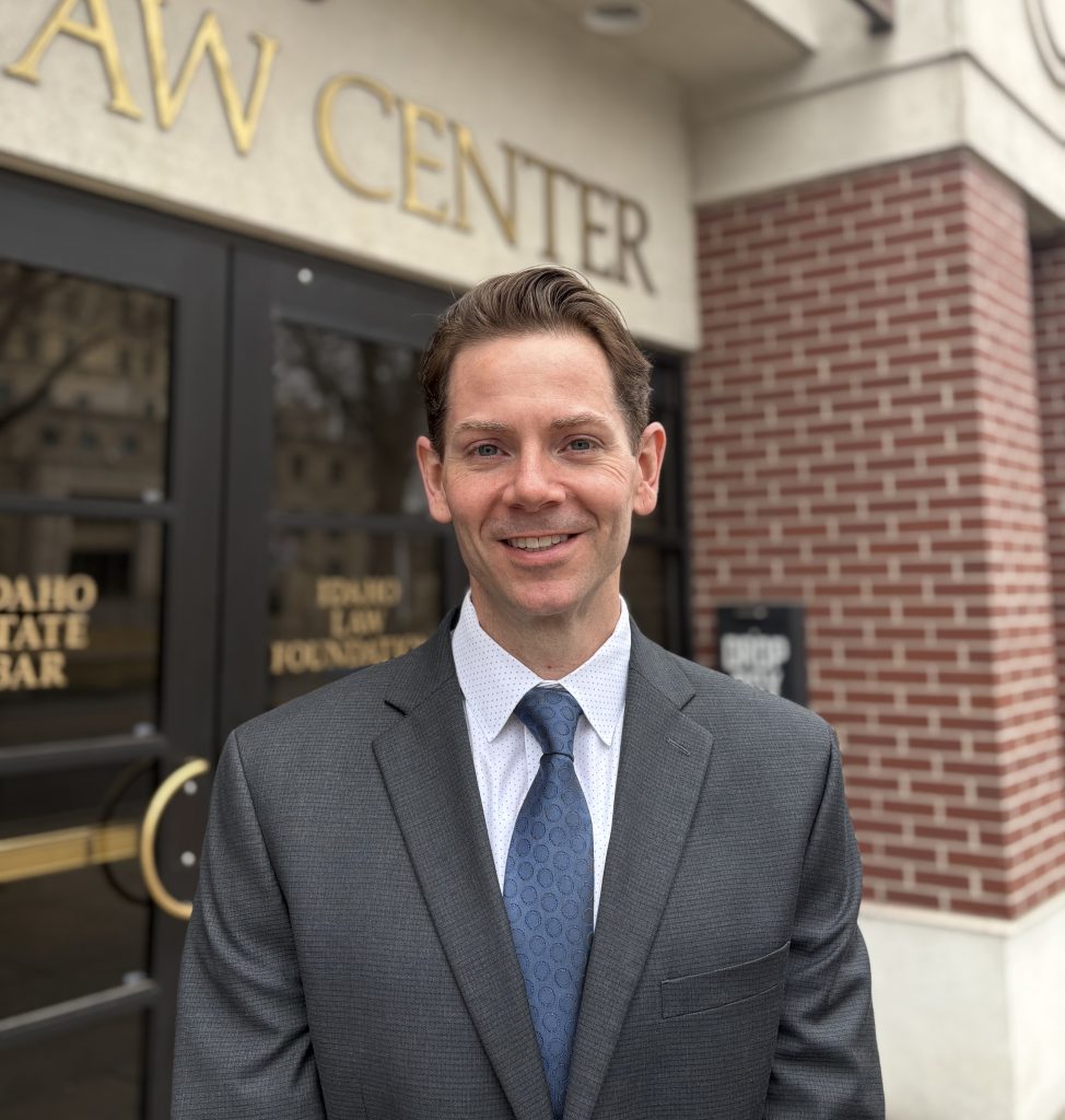 Jared Hoskins smiling in suit outside the Law Center