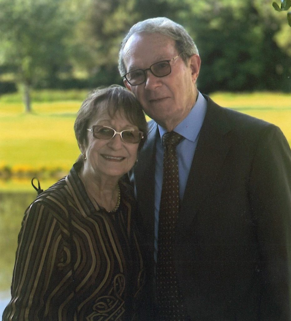 Man and woman smiling together outside.
