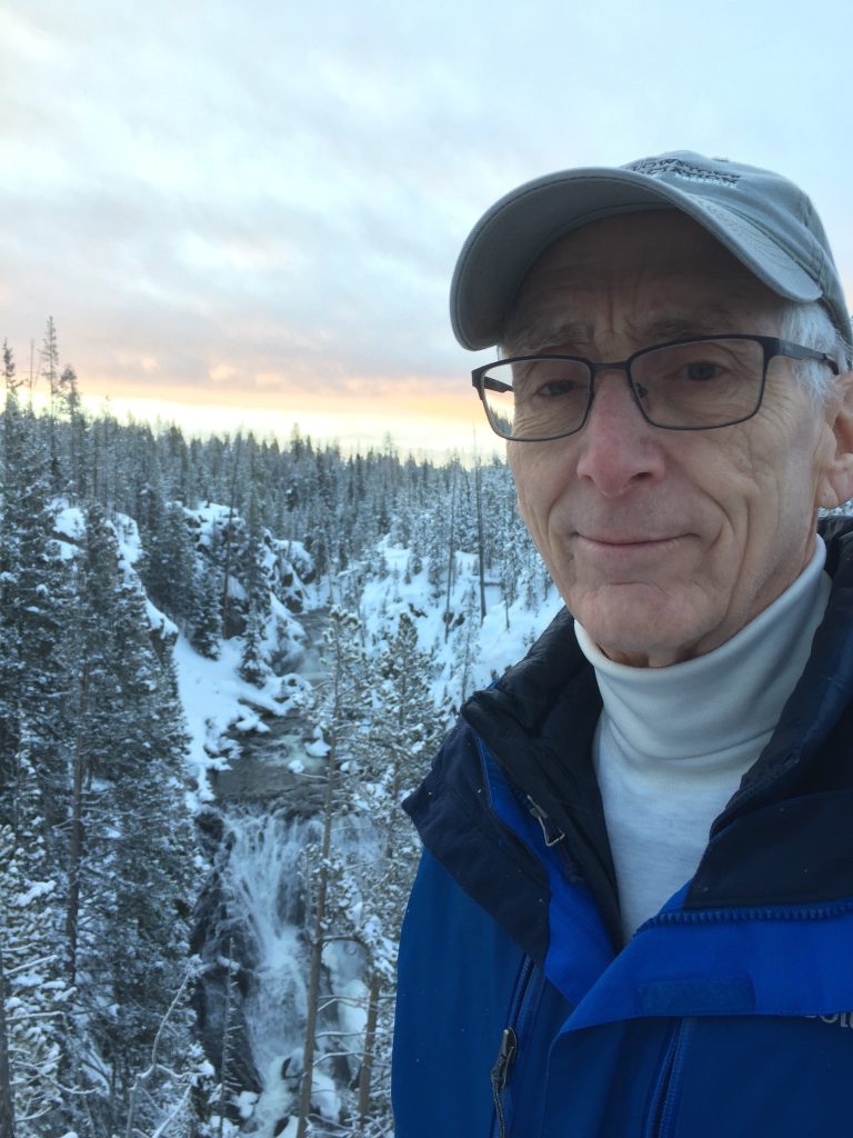man smiling in snowy woods