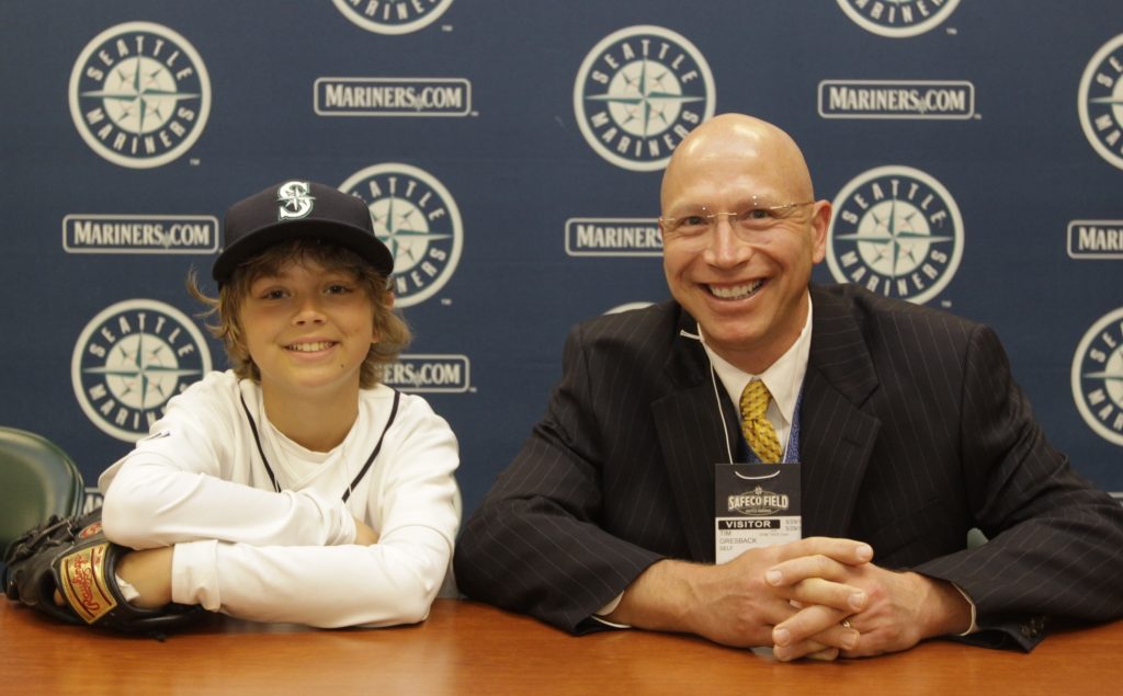 father and son smiling at baseball game