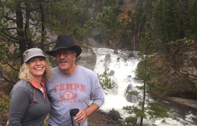 man and woman smiling by a river