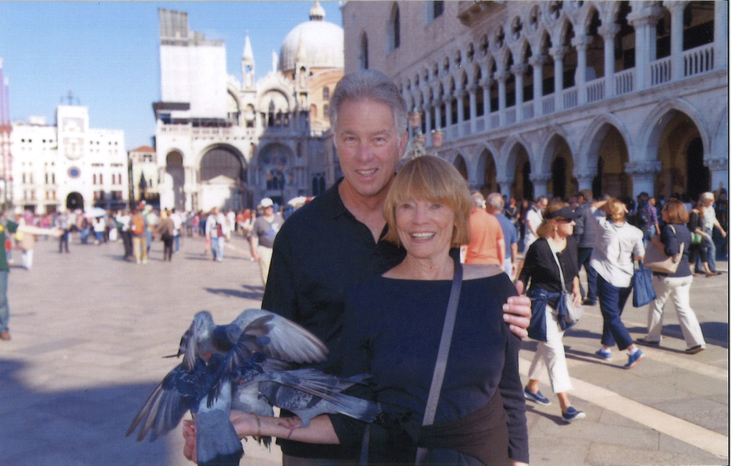 man and woman holding pidgeons in italy