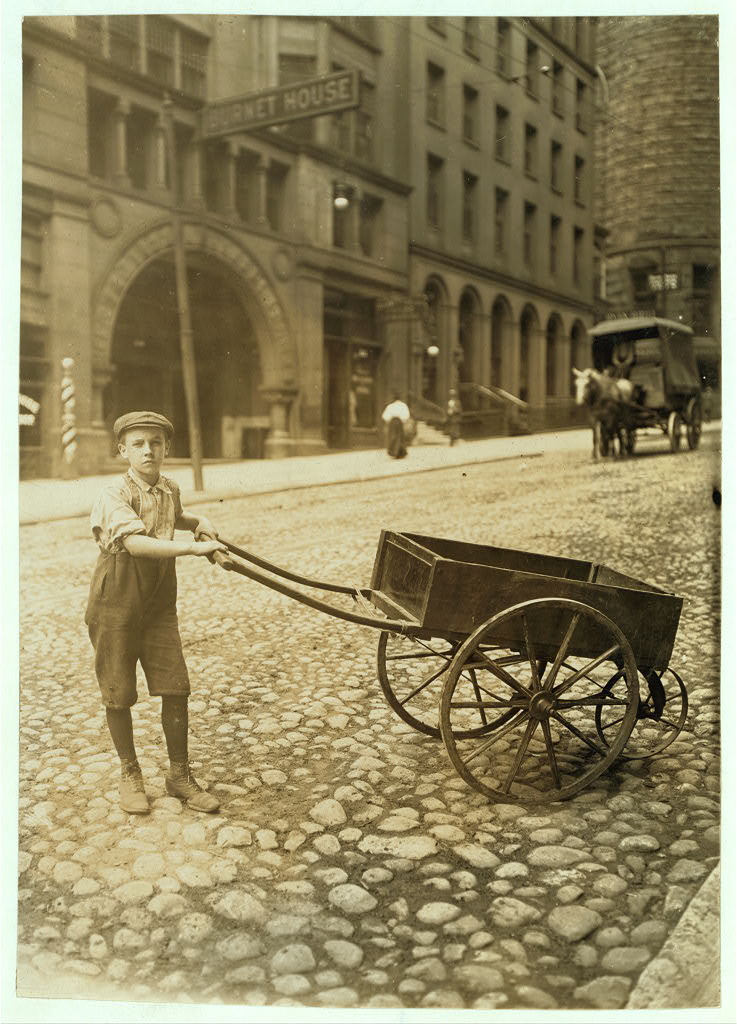 Boy carting wagon in early 20th century.