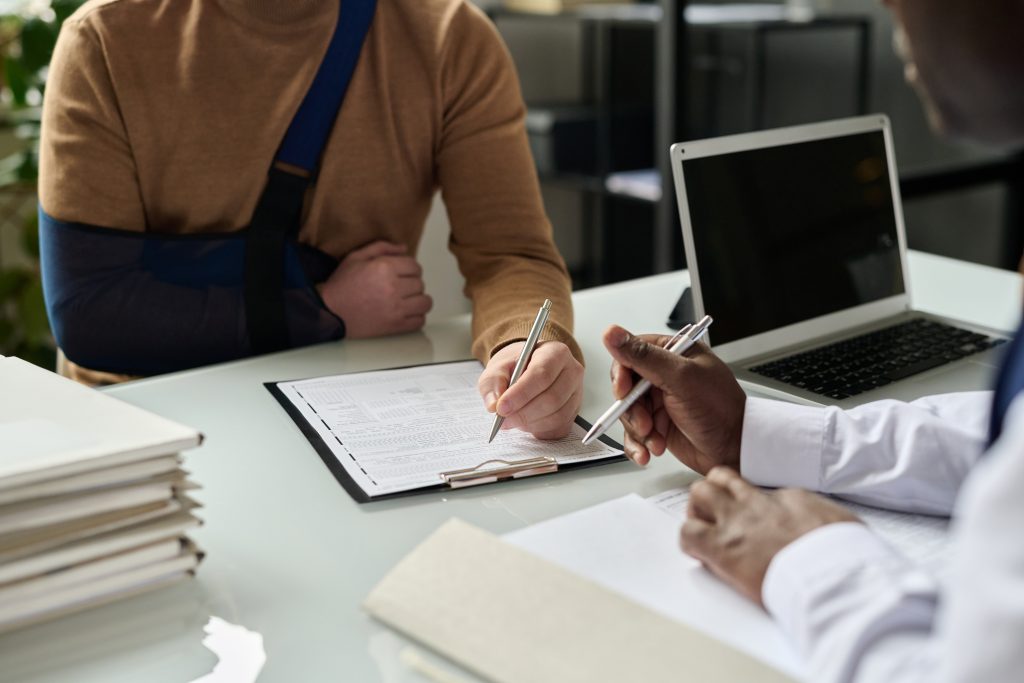image of man with broken arm filling out paperwork