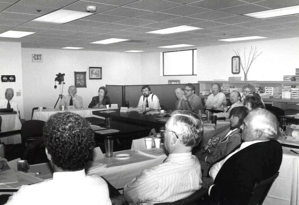 black and white image with people in a classroom in a basement