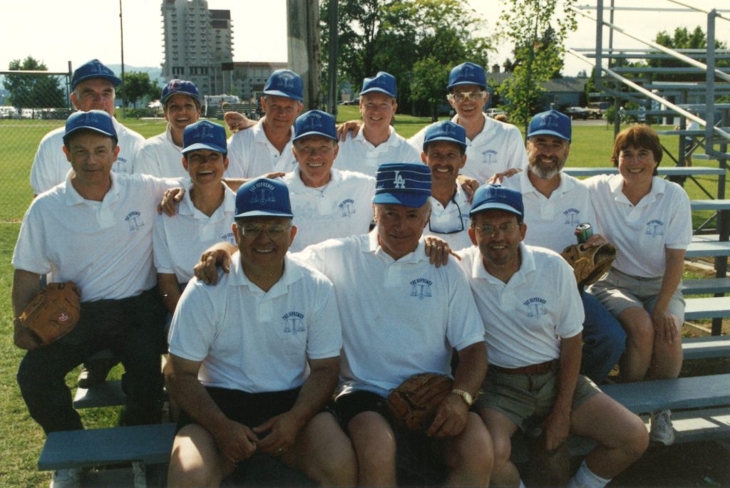 group of people in matching shirts and hats and baseball mitts