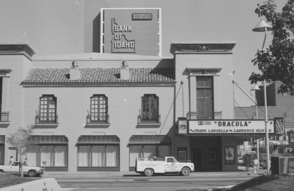 image of old movie theater with "dracula" playing and trucks in front of street view