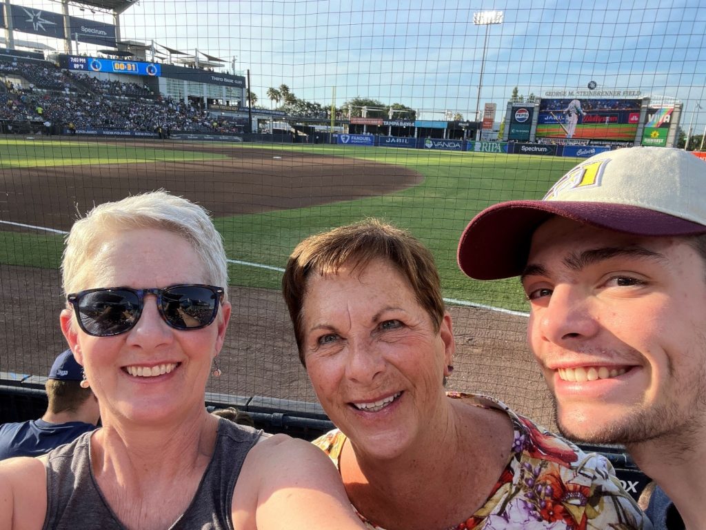 Taking in a ball game in Tampa Bay in 2025. Because the Tampa Bay Rays’ home stadium, Tropicana Field, suffered severe damage during Hurricane Milton in 2024, the Rays played all of their home games in 2025 at George Steinbrenner Field—the regular home of the New York Yankees’ Spring Training and minor league games. Pictured left to right: Judge Lorello; Tonya Clark (mom); Spencer Lorello (son).