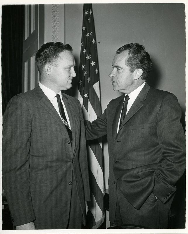 black and white image of James McClure and Richard Nixon in front of american flag