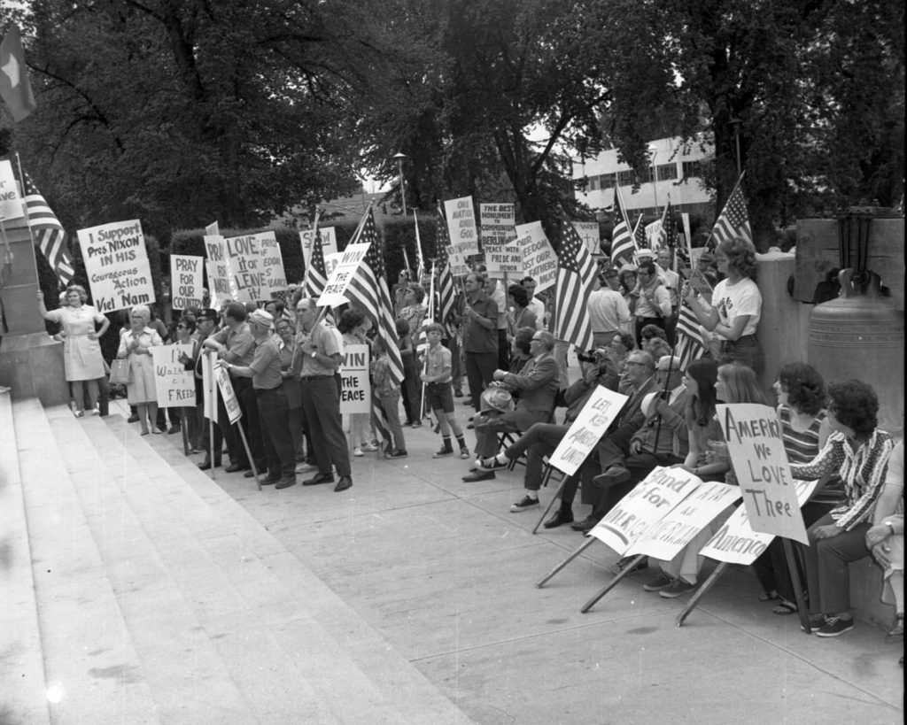 group of protesters with signs on steps