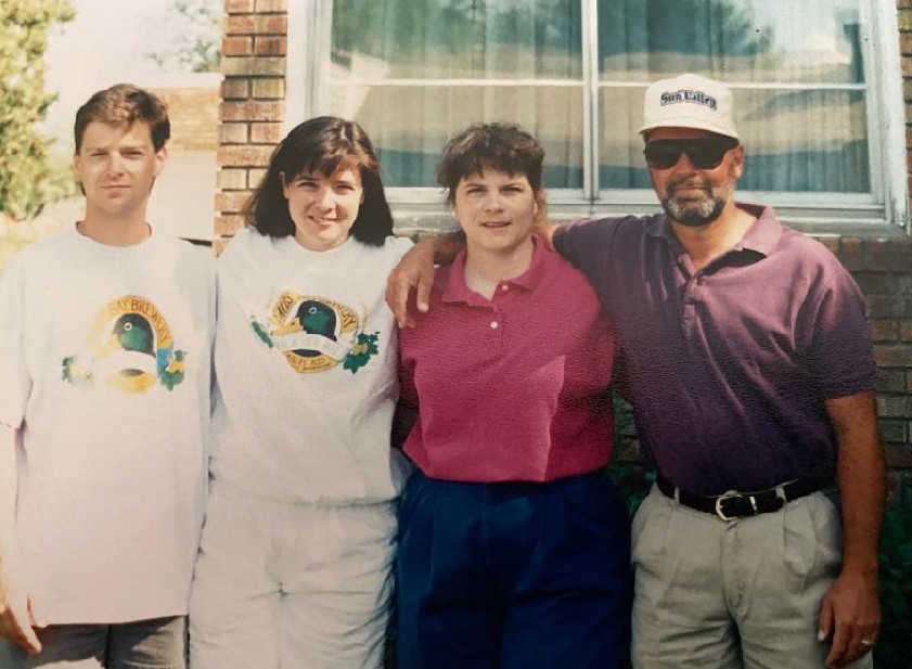 four adults standing outside a country club