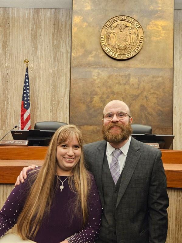 two adults smiling inside supreme court building