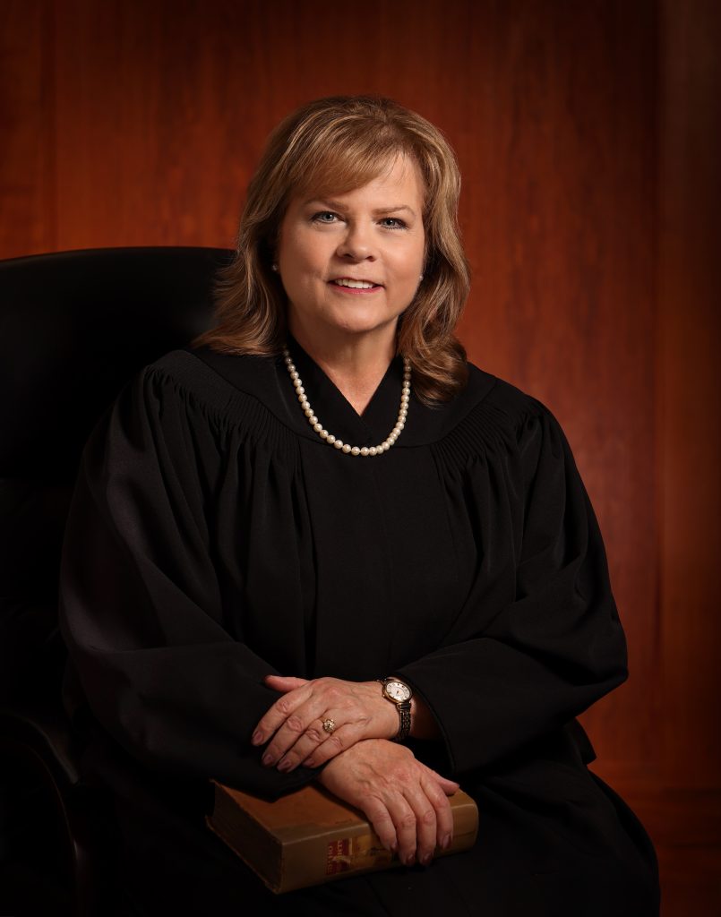 judge sitting in robes smiling