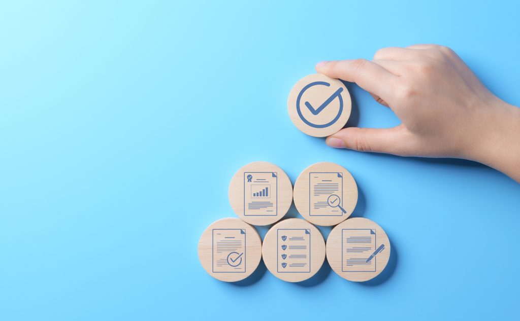 Document quality control concept. Document approve paperless, quality assurance approved. Checklist analyst. Quality certificate Management. Hand-holding wooden block with standardization symbol.