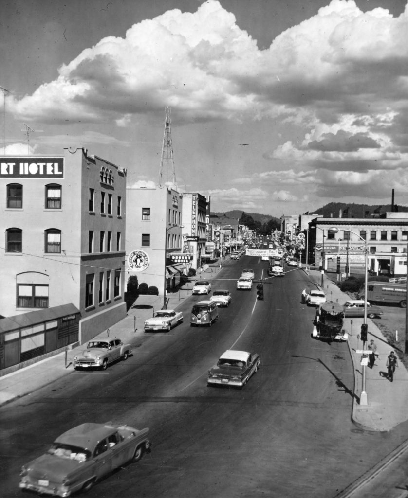 black and white image of coeur d'alene idaho from the 1950s, street view with cars and buildings