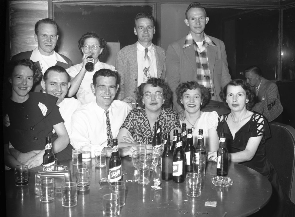 group of friends drinking and smiling together in black and white image.