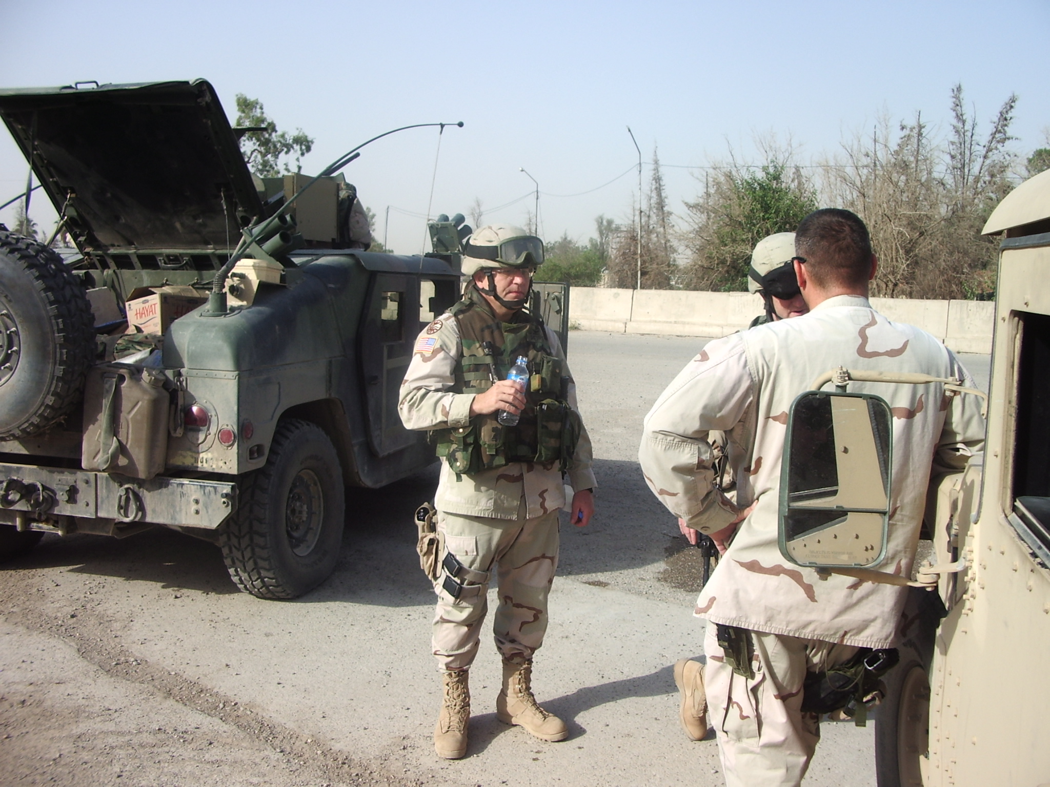 Gordon Petrie talking to the driver of his HUMVEE as they prepared to convoy to the government building in Kirkuk in the early Fall of 2005 for the day&rsquo;s work there.