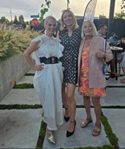 three women in dresses outdoors smiling