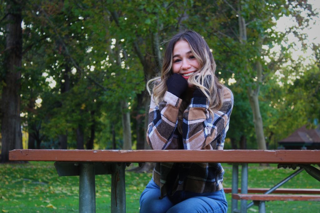 woman smiling sitting outside at a table