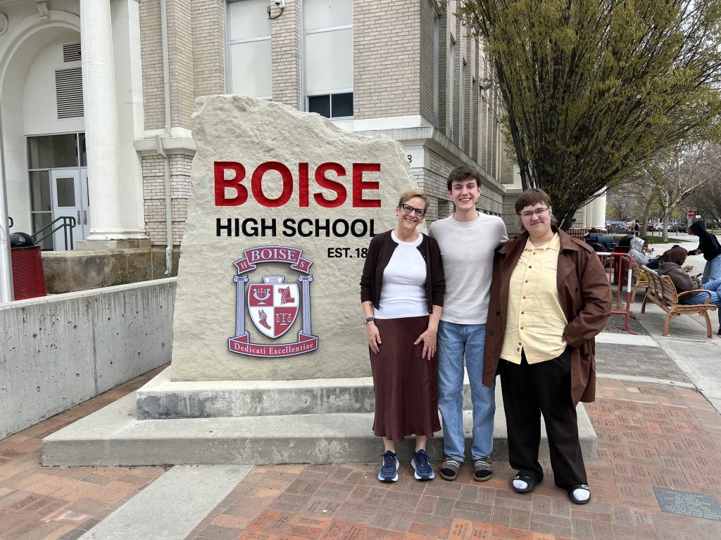 carey shoufler with two students smiling in front of boise high school